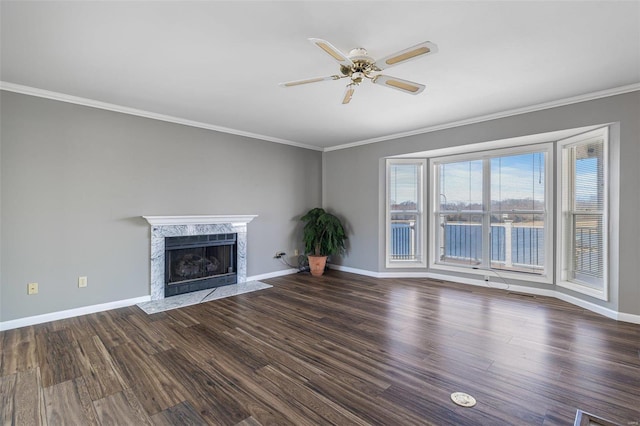 unfurnished living room with crown molding, a high end fireplace, dark hardwood / wood-style floors, and ceiling fan