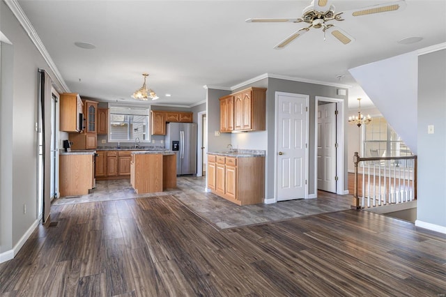 kitchen with crown molding, stainless steel fridge with ice dispenser, dark hardwood / wood-style flooring, a kitchen island, and stove