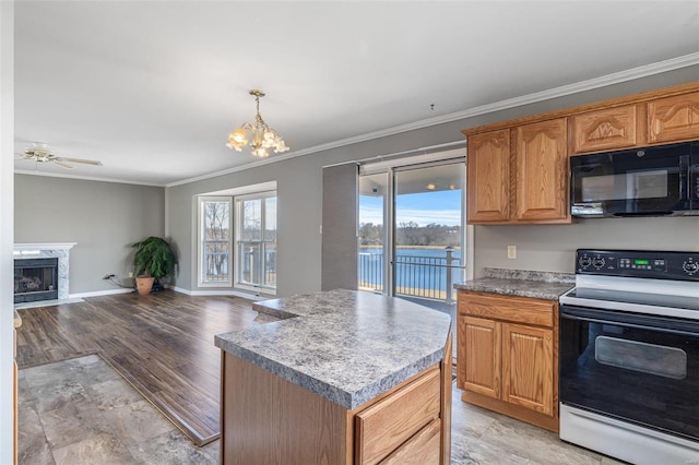 kitchen with pendant lighting, crown molding, a kitchen island, range with electric cooktop, and a premium fireplace