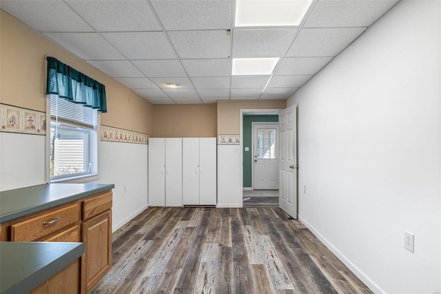 kitchen featuring dark hardwood / wood-style flooring, a paneled ceiling, and a healthy amount of sunlight