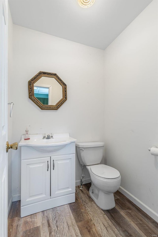 bathroom featuring vanity, wood-type flooring, and toilet