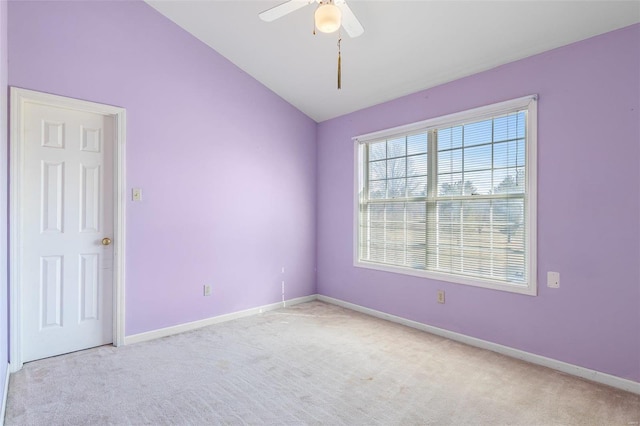 empty room featuring vaulted ceiling, light colored carpet, and ceiling fan