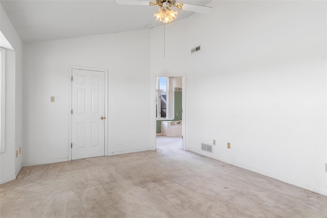 carpeted spare room with high vaulted ceiling and ceiling fan