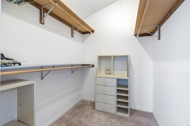 walk in closet featuring light colored carpet