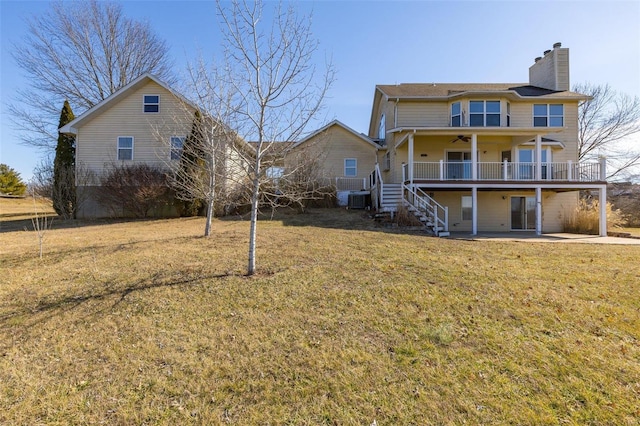 rear view of house with ceiling fan, a yard, and a patio area