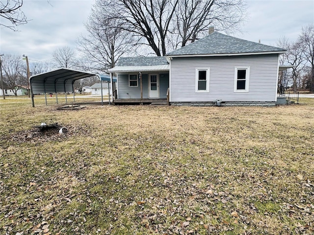 rear view of house featuring a carport, a porch, and a lawn