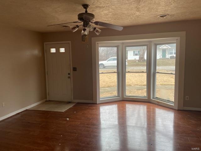 entryway featuring hardwood / wood-style flooring, ceiling fan, a healthy amount of sunlight, and a textured ceiling