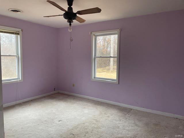 spare room with plenty of natural light, carpet, and ceiling fan