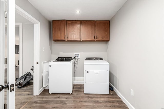 washroom featuring cabinets, dark hardwood / wood-style floors, and washer and clothes dryer