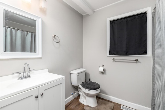 bathroom with wood-type flooring, vanity, and toilet