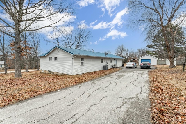 view of side of home with a garage, an outbuilding, and central AC unit