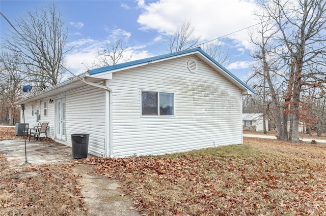 view of property exterior with central AC unit and a patio area