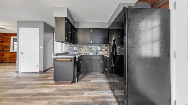 kitchen featuring sink, backsplash, light wood-type flooring, and black appliances