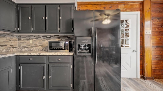 kitchen featuring light wood-type flooring, decorative backsplash, black refrigerator with ice dispenser, and gray cabinets