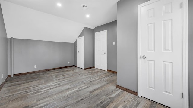 additional living space with lofted ceiling and light wood-type flooring