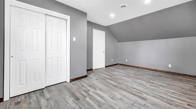 additional living space featuring vaulted ceiling and light hardwood / wood-style floors