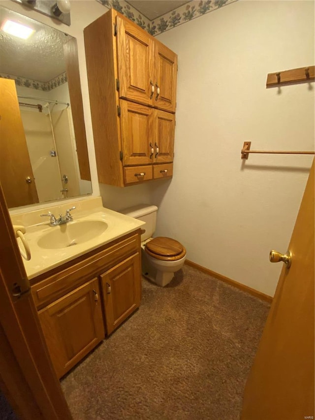 bathroom with vanity, toilet, and a shower