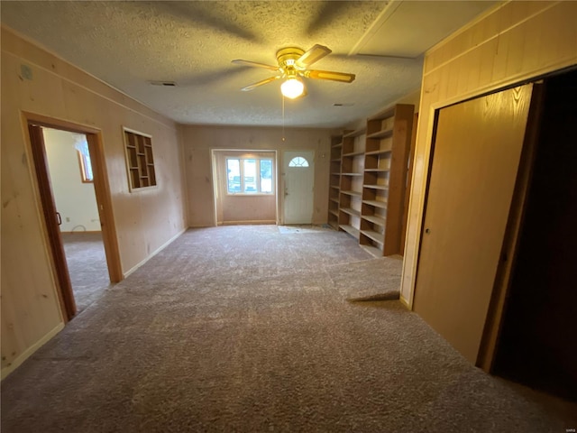 carpeted empty room featuring ceiling fan and a textured ceiling