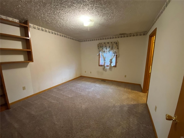 carpeted spare room featuring a textured ceiling