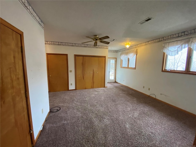 unfurnished bedroom with multiple closets and carpet