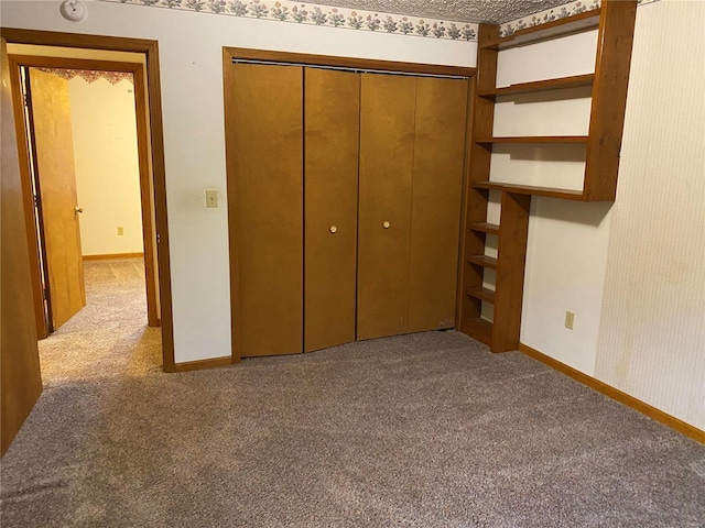 unfurnished bedroom featuring carpet flooring and a closet