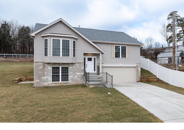 split foyer home featuring a garage and a front yard