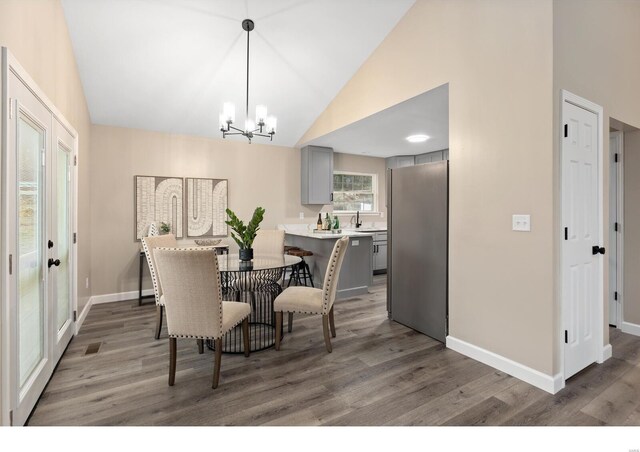 dining area featuring an inviting chandelier, sink, and dark hardwood / wood-style floors