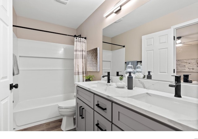 full bathroom featuring shower / tub combo with curtain, toilet, vanity, hardwood / wood-style flooring, and ceiling fan