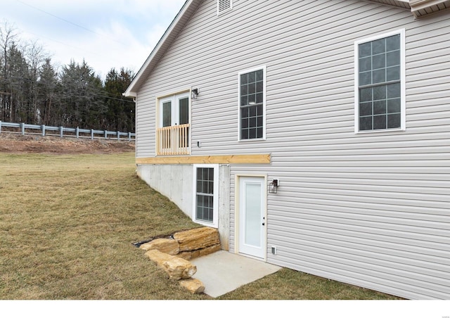 view of exterior entry with a lawn