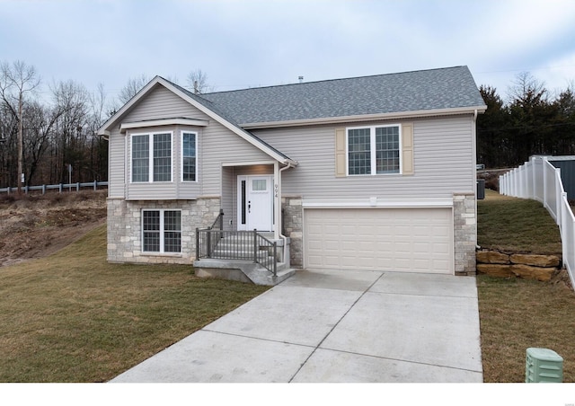 split foyer home featuring a garage and a front lawn