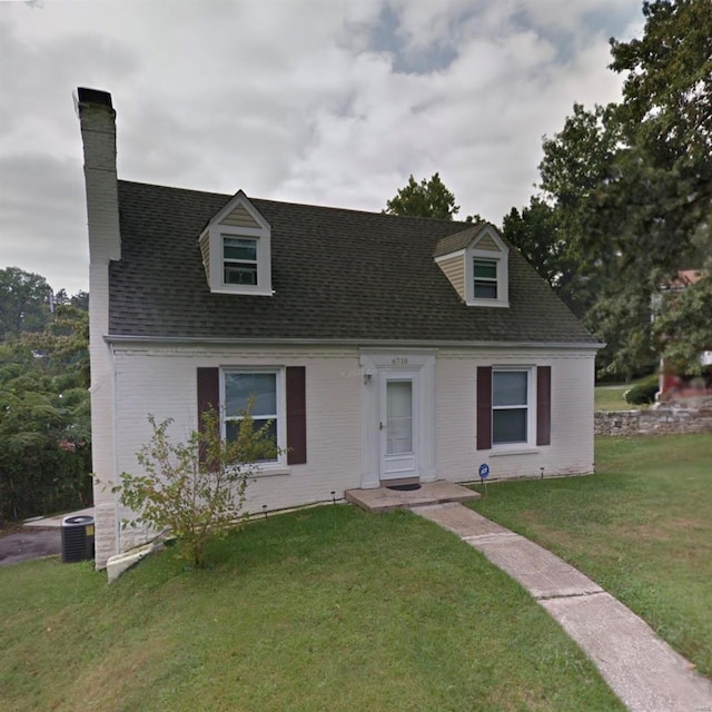 new england style home featuring central AC unit and a front yard