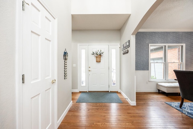 entrance foyer with wood-type flooring and ornamental molding