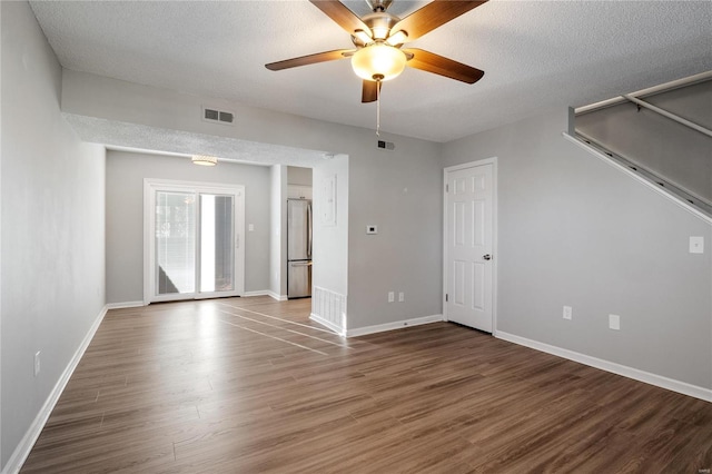 unfurnished room featuring ceiling fan, dark hardwood / wood-style floors, and a textured ceiling