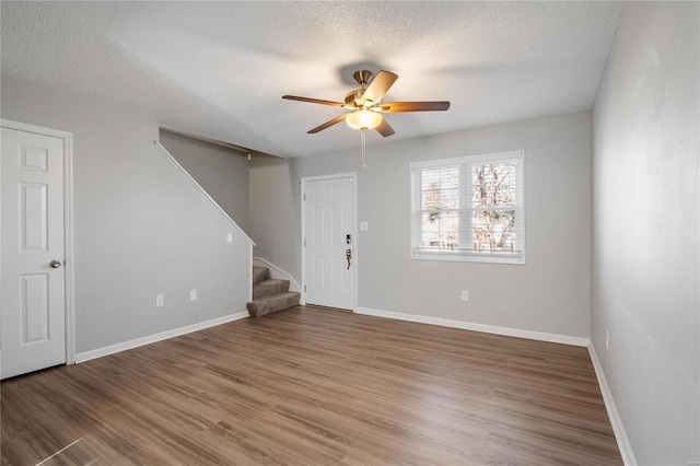 unfurnished room with ceiling fan, hardwood / wood-style floors, and a textured ceiling