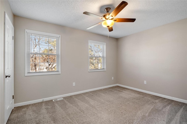 carpeted spare room with ceiling fan and a textured ceiling