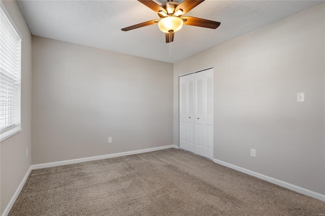 carpeted empty room featuring ceiling fan and a textured ceiling