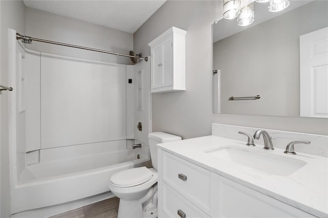 full bathroom featuring hardwood / wood-style flooring,  shower combination, vanity, a textured ceiling, and toilet