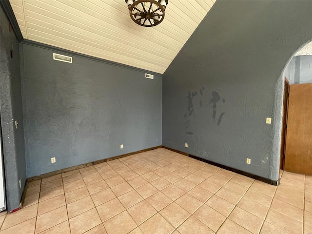 tiled spare room with wood ceiling and vaulted ceiling