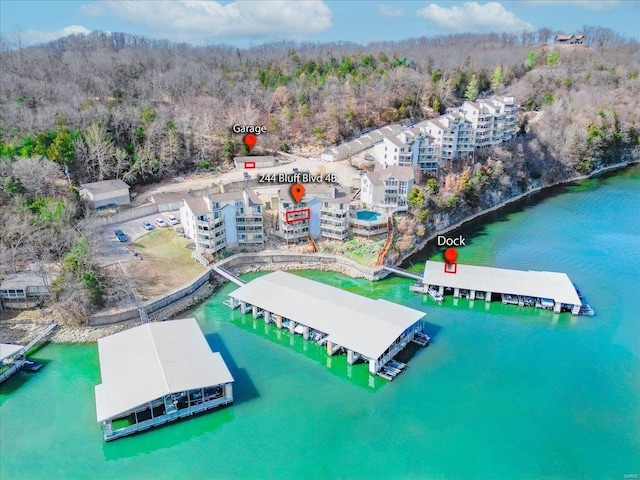 drone / aerial view featuring a forest view and a water view