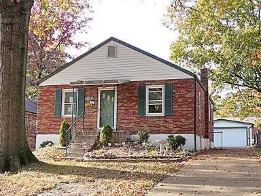 view of front of property featuring a garage and an outdoor structure