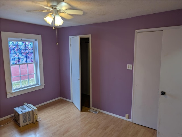 unfurnished bedroom featuring ceiling fan, light hardwood / wood-style flooring, and a textured ceiling