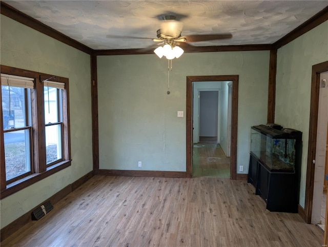 unfurnished living room featuring ceiling fan, ornamental molding, and light hardwood / wood-style floors