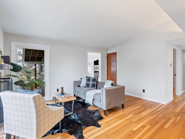 living room featuring lofted ceiling and light wood-type flooring