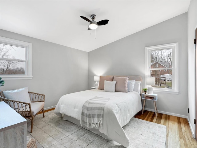 bedroom with ceiling fan, vaulted ceiling, and light hardwood / wood-style flooring