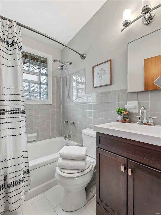 full bathroom featuring shower / tub combo with curtain, tile walls, vanity, tile patterned floors, and toilet