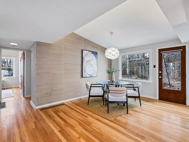 dining area featuring light hardwood / wood-style flooring and vaulted ceiling