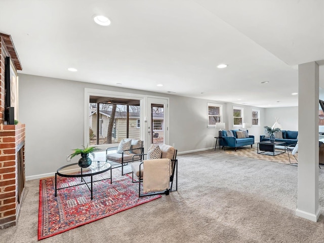 living room with a brick fireplace and light colored carpet