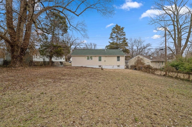 rear view of property featuring a lawn