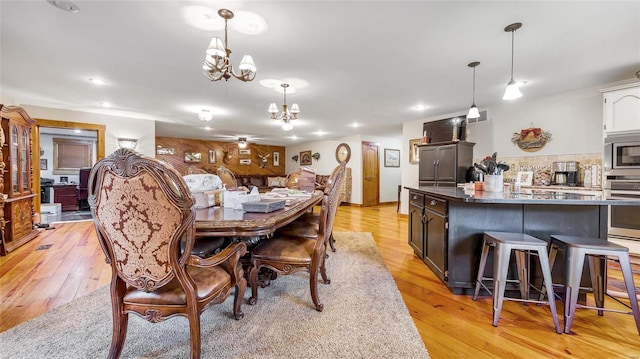 dining room featuring a notable chandelier and light wood-type flooring