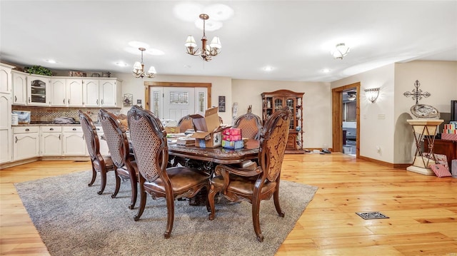 dining area featuring an inviting chandelier and light hardwood / wood-style floors